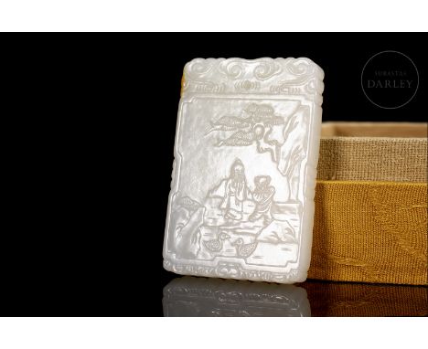 A finely carved jade plaque, smooth and milky with subtle reddish flecks. It is rectangular, with a cut-out profile and round
