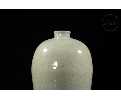 Modelled ceramic adorned with a beautiful celadon glaze in a greyish-blue hue, which covers the carved plant motifs that surr