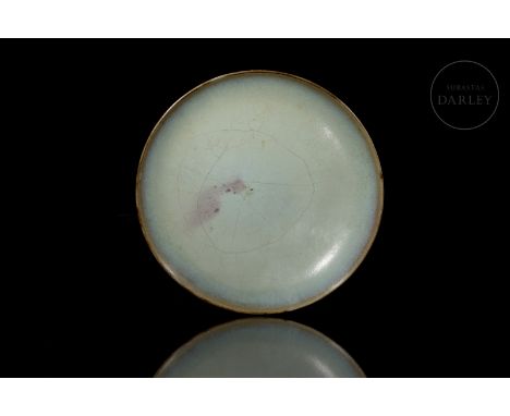 Ceramic modelled in the form of a small dish, with a circular, convex body, standing on a short foot. Decorated with a beauti