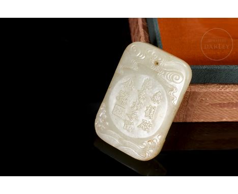 A light-coloured carved jade plaque with mottled patches of reddish or amber. It is rectangular, with rounded edges, and one 