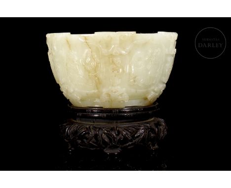 Light-coloured jade with light brownish veining, carved in the shape of a bowl with a circular base and a stepped mouth. It i