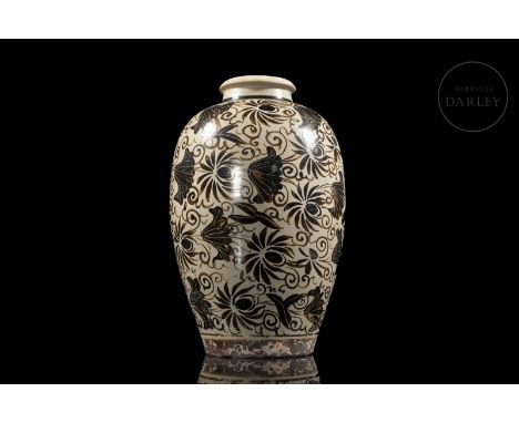 A modelled ceramic vase with a slender, rounded body, a narrow neck and a small mouth with a turned rim. Decorated on the ext