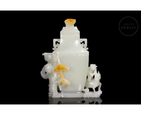 A small white jade vase with intense amber flecks. The vase has an elongated, flat body with two angled handles at the neck, 