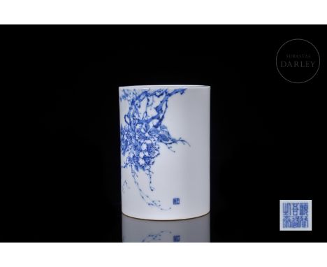 A modelled porcelain vessel decorated with underglaze blue and white enamel. It has a circular base and a cylindrical body, d
