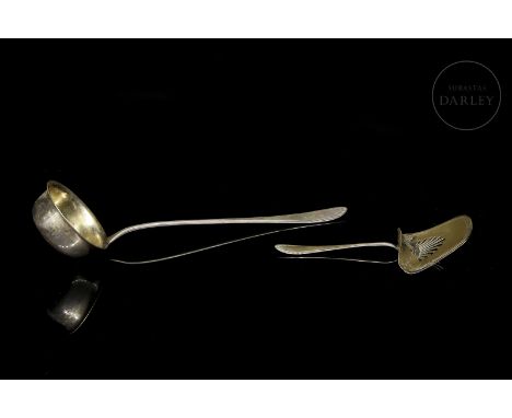 Set of two silver pieces, consisting of a ladle and a spatula with openwork details.Major height: 36 cm; Minor height: 22.3 c