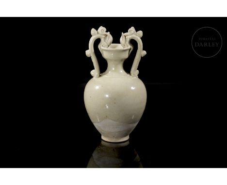 Small ceramic vase covered by an elegant whitish ochre glaze. It has a small circular foot, on which stands a stylized bulgin