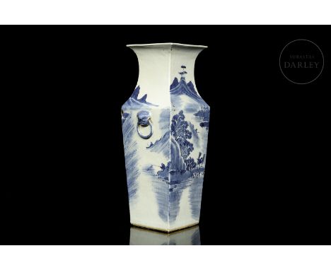 A beautifully glazed ceramic vase with details in blue on a white ground. It has a slender quadrangular body that widens at t