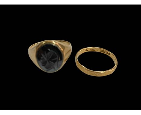 9 carat gold oval carved black stone signet ring, size R and 22 carat gold wedding band, size R.