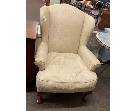 Wing back armchair in light classical fabric.