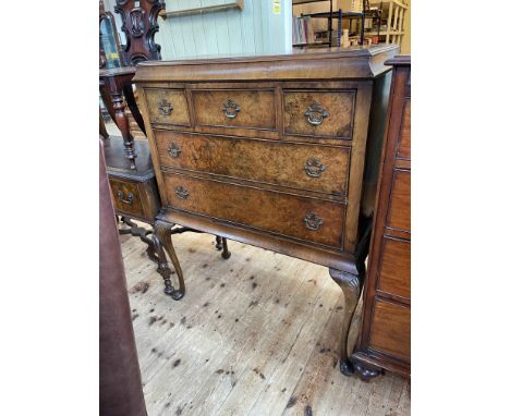 Burr walnut cocktail cabinet having three drawers above a fall front on cabriole legs, 124cm by 103cm by 51cm.