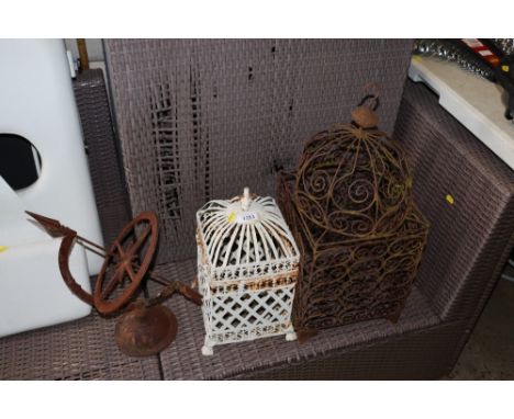 A metal sundial together with two hanging candle lanterns