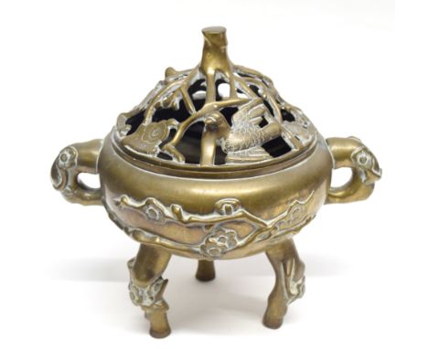 Chinese brass censer and stand mounted on three tripod feet, the cover with pierced decoration of flowers and birds, 26cm hig