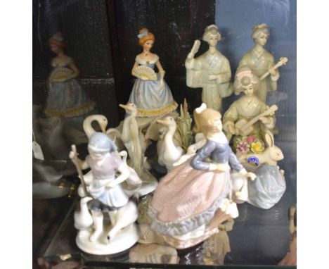 Group of Continental porcelain models of children in various poses, together with a model of two geishas playing musical inst