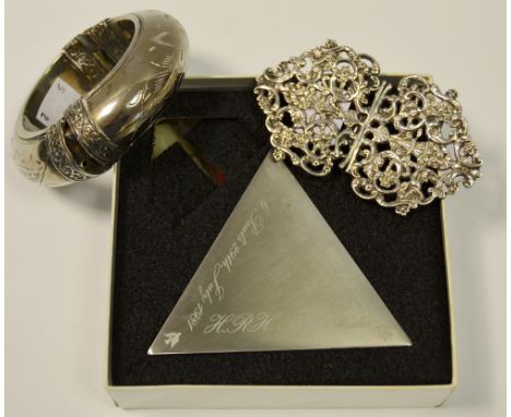 A silver Nurse's buckle cast with flowers and scrolls; a silver coloured metal bangle; a Charles and Diana wedding candlestic