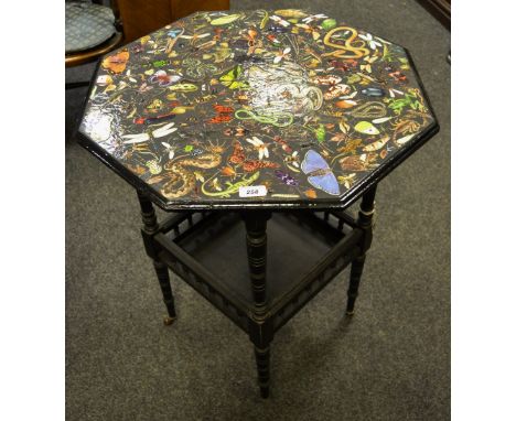 A late Victorian ebonised octagonal occasional table, the top decorated with a collage of fauna in vibrant colours, turned le