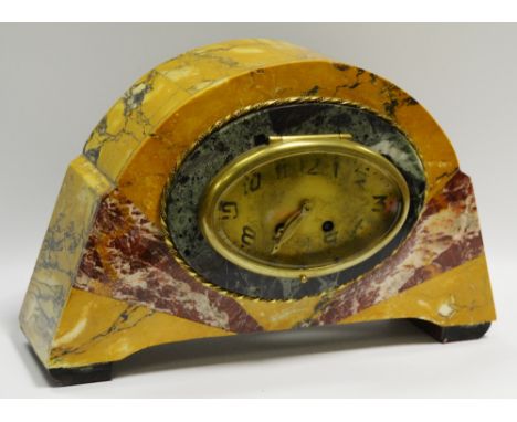 An Art Deco variegated marble mantel clock, oval dial with brass bezel, Arabic numerals.