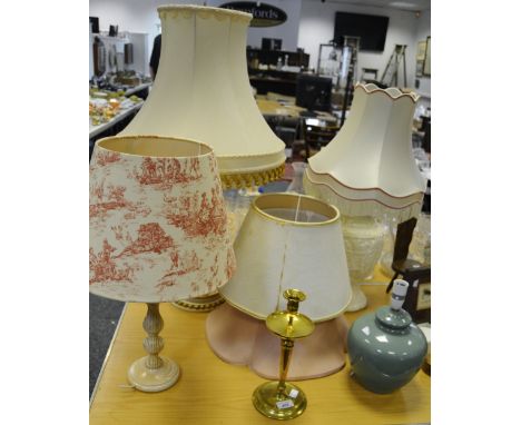 Interior design - a brass candlestick converted to a table lamp; a white resin oriental style lamp base depicting village sce