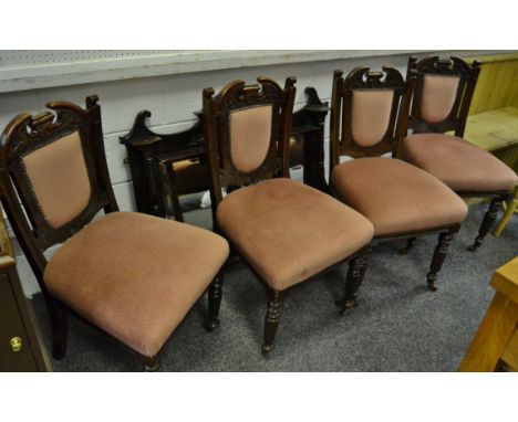 Four Victorian mahogany dining chairs, shaped and carved top rail , padded rail and seat, reeded fore legs, casters c1880; a 