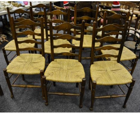 A set of eight oak ladder back dining chairs, rope seats, turned forelegs