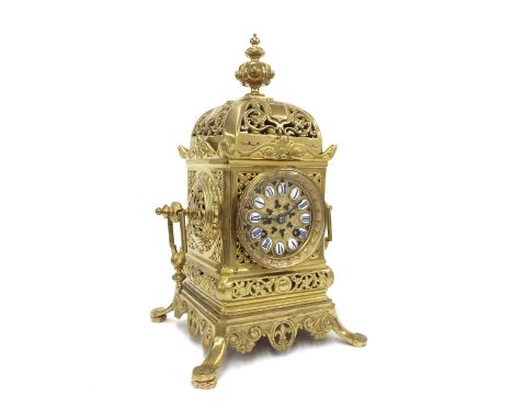 Brass two train mantel clock striking on a bell, the 3" pierced brass dial with Roman cartouche enamel numerals, within an or