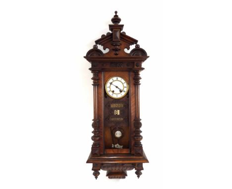 Walnut Vienna two train calendar wall clock, the 5.25" white dial over three date apertures, within a pillared carved case (g