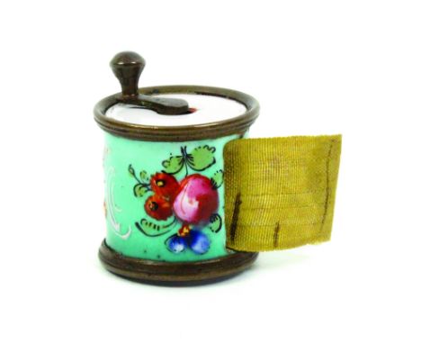 A good English enamel late 18th Century cylinder tape measure the blue ground decorated with raised flowers, leaves and white