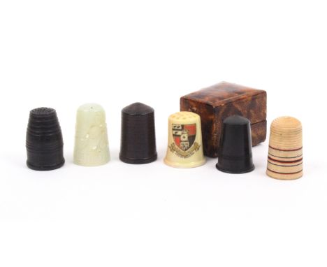 Six various thimbles comprising a Worcester porcelain example decorated with the arms of Worcester, cased, a 19th Century tur