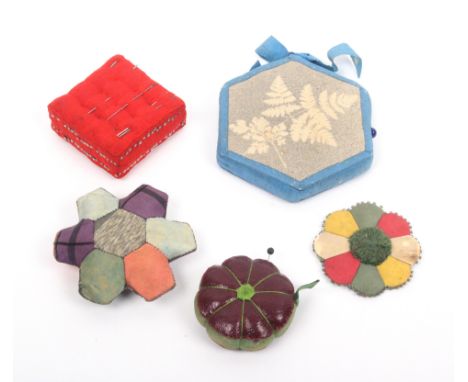 Five attractive pin cushions comprising two patch work examples, 6 and 5cm, a buttoned cushion form example, 5cm, a leather p
