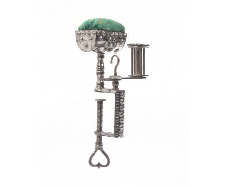 An early 19th Century cut steel sewing clamp the decorated rectangular frame with heart pierced screw terminal below a trough