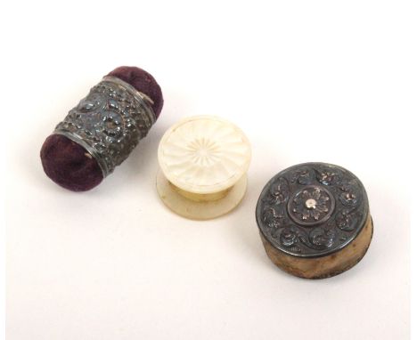 A pin cushion and two waxers, the silver girdle pin cushion decorated with flowers, 3cm, a similar disc form waxer, 2.5cm, an