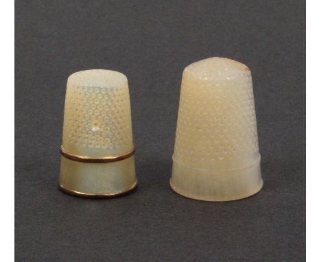 Two 19th Century mother of pearl thimbles comprising an example with plain frieze between two copper gilt bands, crack or nat