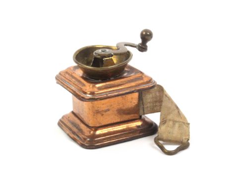 A brass and copper novelty tape measure in the form of a coffee grinder, the complete tape printed in inches, 4cm