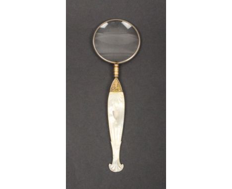 A Palais Royal magnifying glass, the mother of pearl carved handle inset to one side with a silver shield the gilded mount be