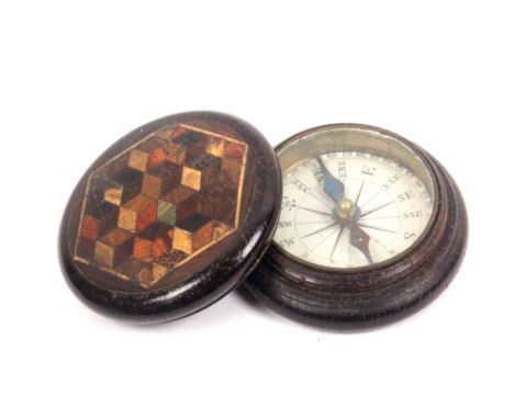 A Tunbridge ware circular rosewood box containing a compass, the lid with a hexagonal panel of cube work, 4cm dia