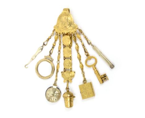 A gilt metal chatelaine in the 18th Century style, the mount with an oval panel depicting a garden terrace with seven variant