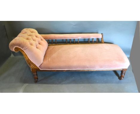 A Victorian Chaise Longue with a button upholstered scroll end raised upon turned legs 