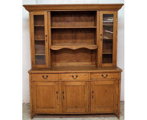 A 20th century pine kitchen dresser, the two tier plate rack flanked by cupboard doors, over three short drawers, on bracket 