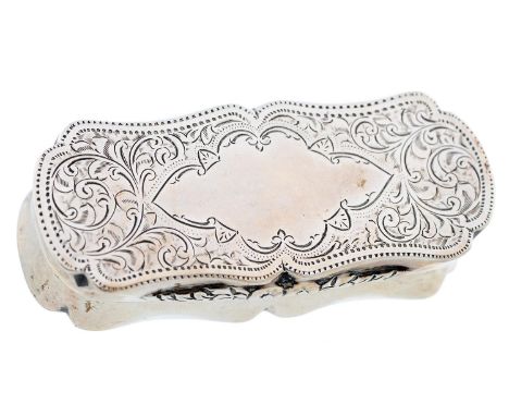 An Edwardian silver snuff box, of shaped outline with waisted sides, the lid engraved with scrolling foliage around a vacant 