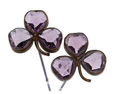 A pair of steel hatpins, c1900, with amethyst paste set brass clover leaf terminal, 21cm l  Good condition