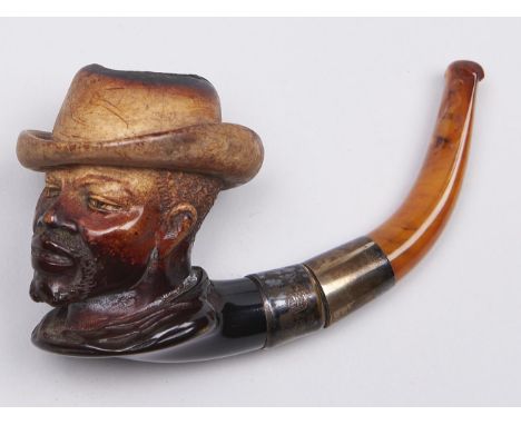 A Meerschaum tobacco pipe, the bowl carved as the head of a man in a hat, c1900, detachable silver mounted amber mouthpiece, 