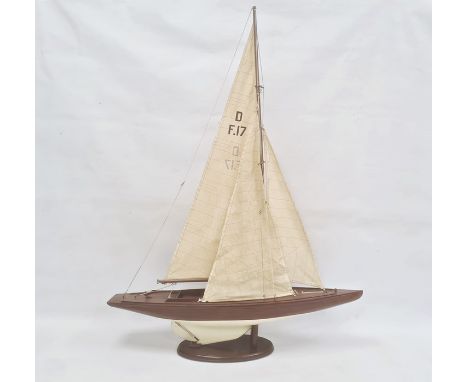 Varnished and painted wood model yacht with canvas sails and the associated wooden stand, 102cm high overall