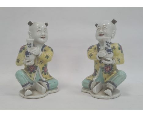 Pair of Chinese porcelain seated figures, laughing boys, each holding a blue and white vase, 16cm highCondition ReportBoth ha