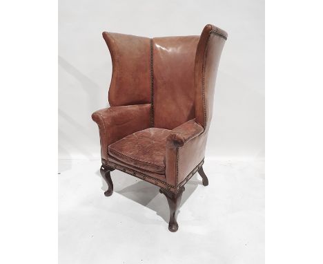 Possibly early 20th century wing back chair stamped Gregory and co in light brown leather with brass studding, on cabriole fr