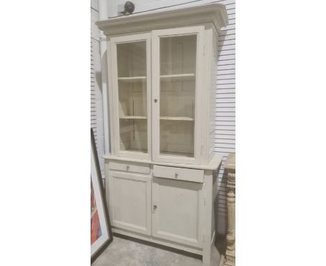 Grey painted bookcase cabinet with moulded cornice above two glazed doors enclosing shelves, two drawers and two cupboard doo