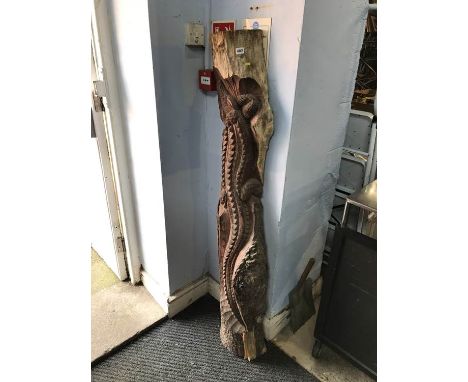 A trunk of a tree with carved decorative crocodile