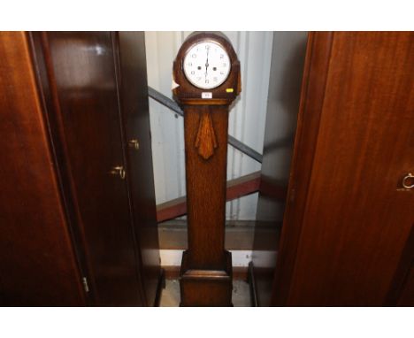 A 1930's two hole granddaughter clock - pendulum on rostrum 