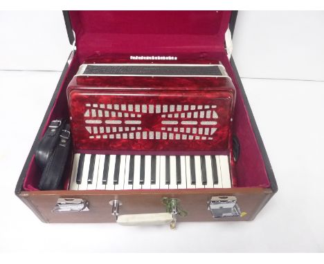 Piano accordion in marbled red, unbranded, in carry case.