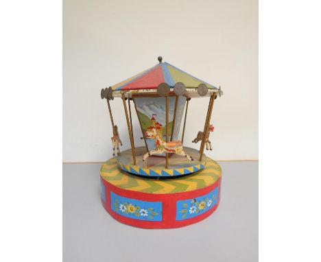 Vintage scratch built wooden carousel in bright polychrome painted finish, the canopy with applied British pennies. Height 44