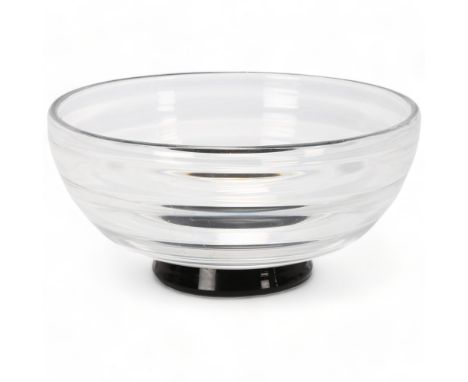 EDWARD HALD for Orrefors, Sweden, a clear glass ribbed bowl on black foot, marked to base Of HU 103, diameter 18.3cmsome inte