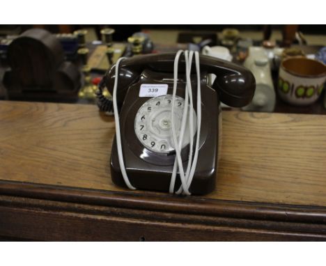 A brown plastic rotary dial telephone 